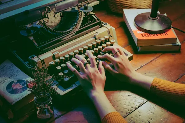 Image of hands typing on a retro typewriter.